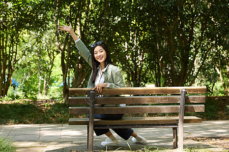 坐在长椅上摆可爱姿势的女孩图片