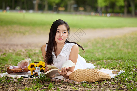 趴在野餐垫上的美女形象图片