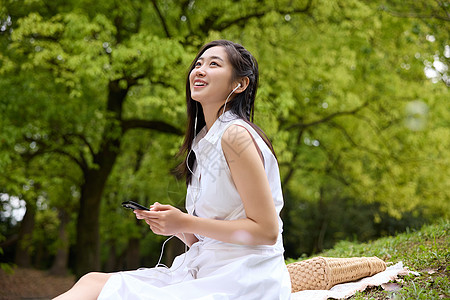 坐在野餐垫上休息的美女图片