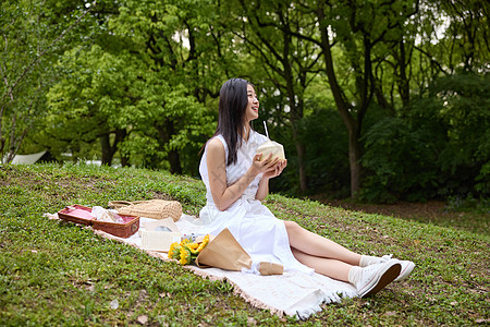 坐在草地上野餐的女孩图片