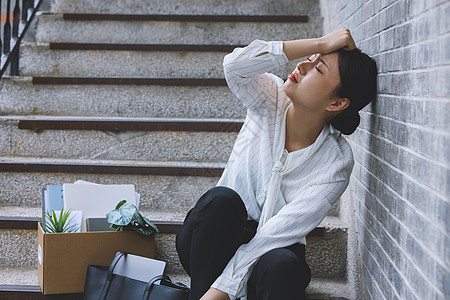 被裁员的女职员靠在楼梯墙边伤心图片