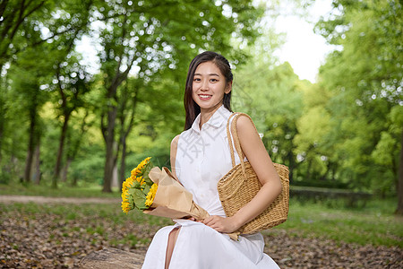 户外抱着向日葵花束的美女图片