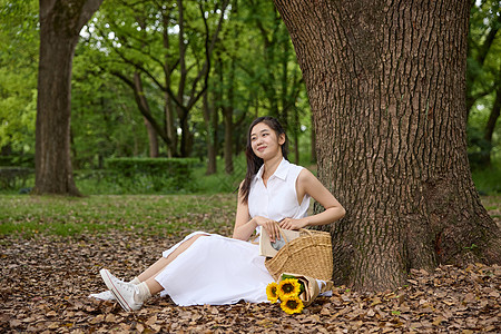 户外靠着大树坐下的女性图片