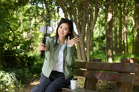 美女拿着自拍杆录视频图片