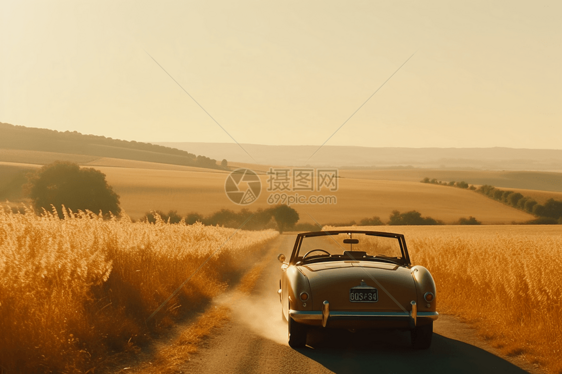 一辆敞篷车蜿蜒穿过金色麦田的丘陵和山谷图片