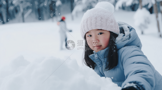 一个中国小姑娘在茫茫白雪中堆雪人图片