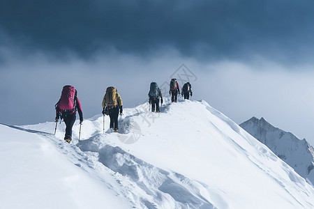 登山者爬上一座雪山图片