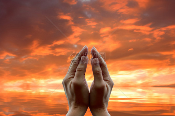 日落下祈祷的双手图片