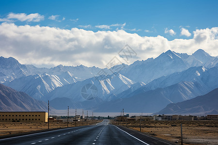 空旷的公路和远处的雪山背景图片