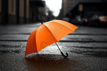 明亮的橙色雨伞放置在潮湿的路面上图片