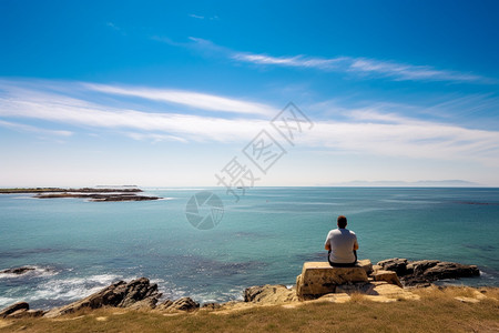 男士坐在海边岩石上图片