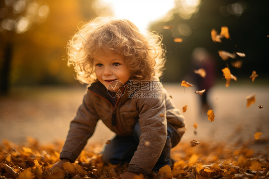 秋天落叶堆里的男孩图片