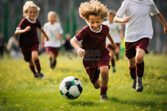 草坪中踢足球的孩子图片