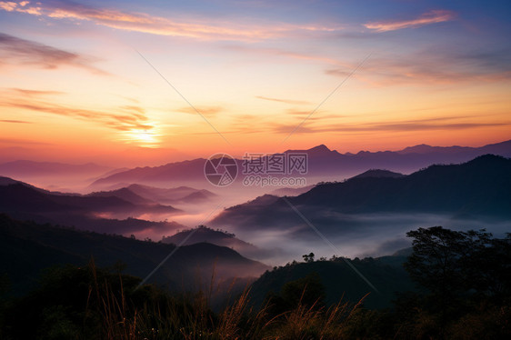 日出时迷雾笼罩的山脉景观图片