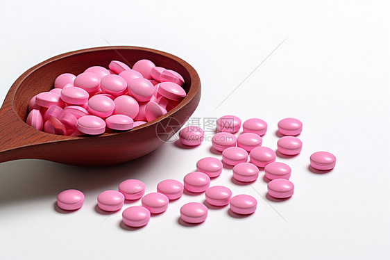 木勺中的粉色药丸图片