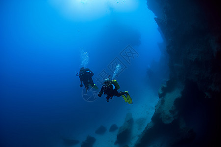 深海潜水员在光束照耀下游泳图片