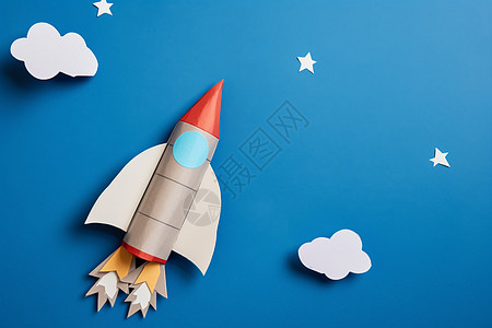 蓝天白云中飞舞的星星纸火箭图片