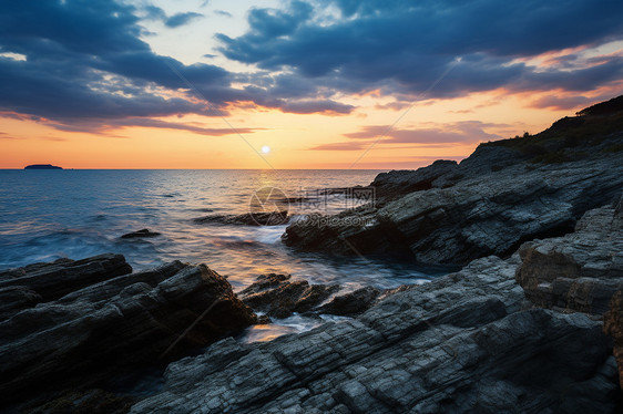 岸边石头上的夕阳图片