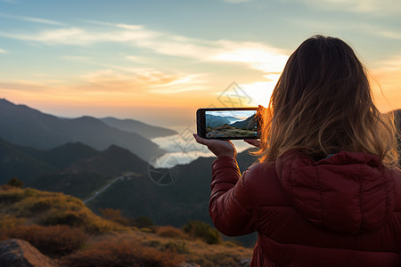 山顶上手机风景的女子图片