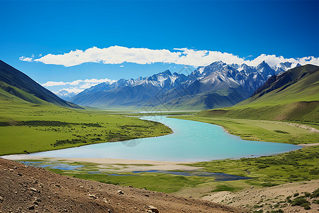 山脉下的山谷中的湖泊与草地高清图片