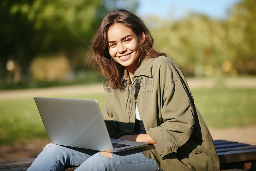 树下的女人用笔记本电脑图片