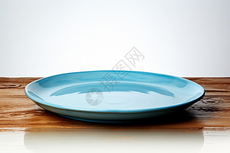 木桌上的蓝色陶瓷盘子图片