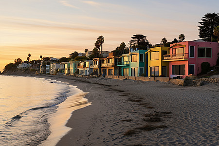 夕阳下海滩边一排房屋图片