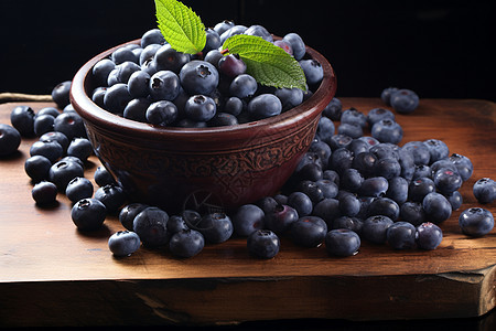 蓝莓与木桌上的叶子摆放在一起图片