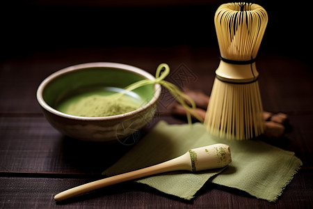 一碗绿色粉末旁边放着一把竹刷子和搅拌器图片