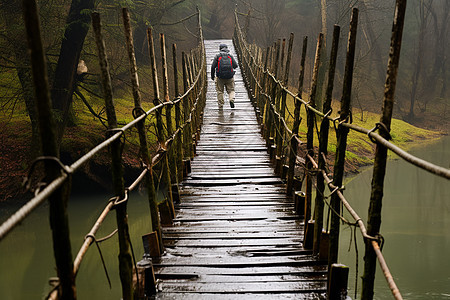 雨中人行吊桥上的旅行者图片