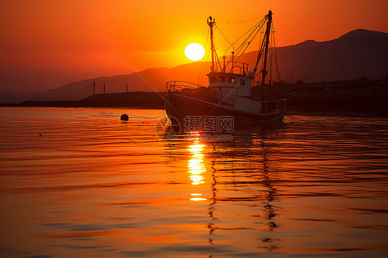 夕阳映照下的渔船图片