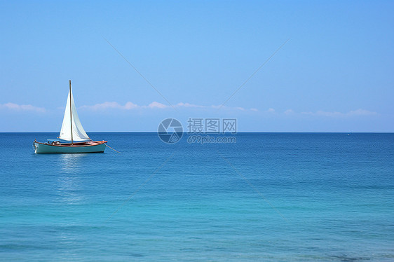 平静海面上漂浮的帆船图片