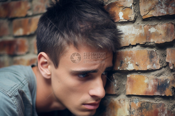 砖墙前失落沮丧的男子图片