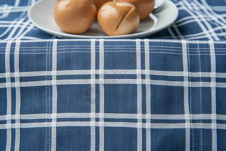 蓝色条纹桌布上的卤鸡蛋图片