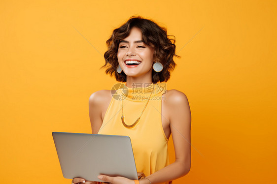 黄衫女子手拿笔记本电脑图片