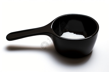一勺装有糖的黑色量勺图片