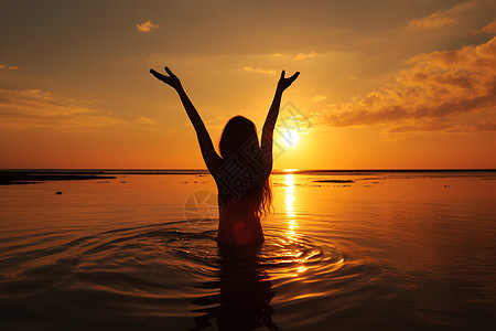 海边日落海边的女子夕阳下张开双臂背景