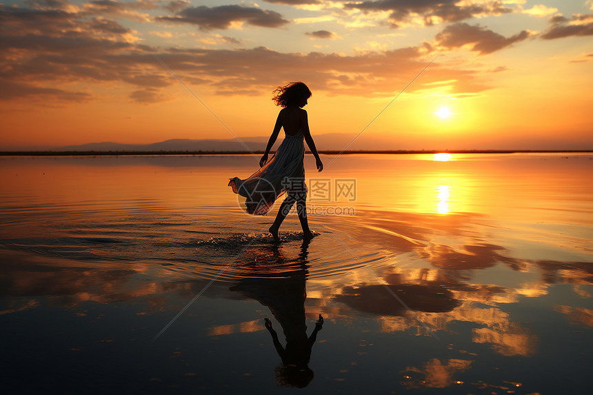 夕阳下海滩上的女子图片
