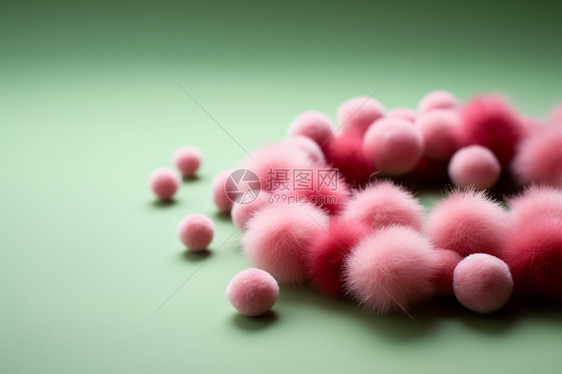 粉色毛球堆叠在绿色表面上图片