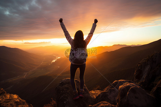 日出攀登山顶的女子图片