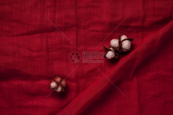 红色亚麻布料上的棉花图片