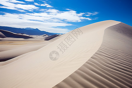 蓝天白云下的巨大沙丘背景图片