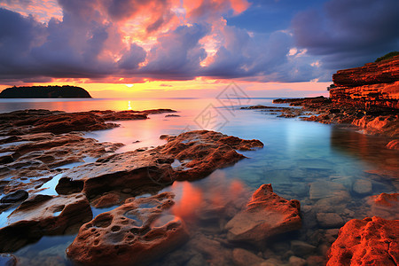 岩石海滩上的日落背景图片