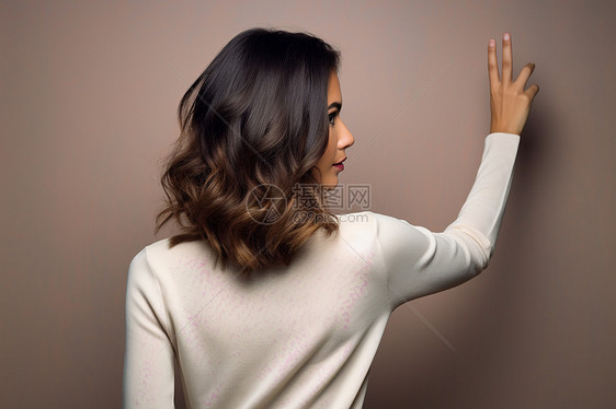 女士将手举在墙上图片