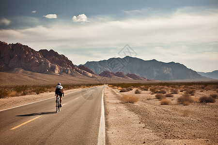 骑自行车者在荒漠路上疾驰图片