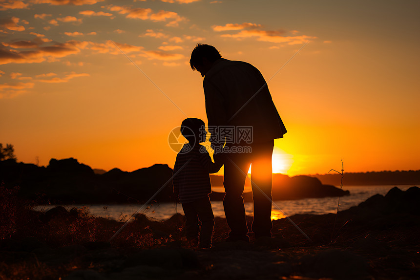 日落时海边的父子图片