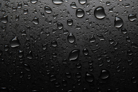 雨后黑色玻璃上的雨滴设计图片