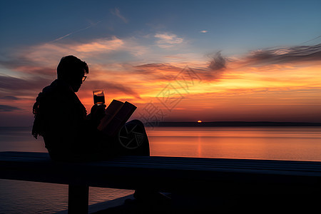 黄昏时海边看书的男人背景图片