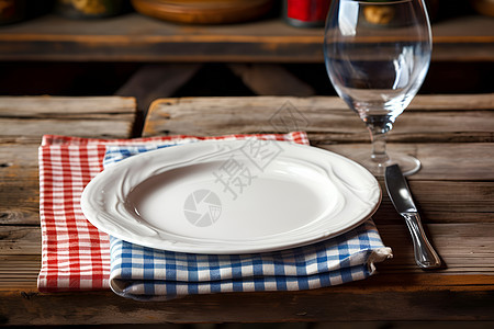 格子餐布上的白色盘子背景图片