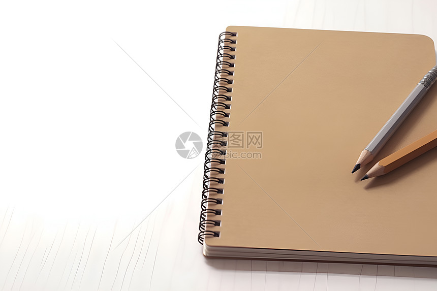 笔记本旁边放着一支铅笔图片
